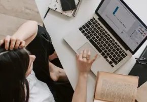 Professional reviewing case studies on a laptop
